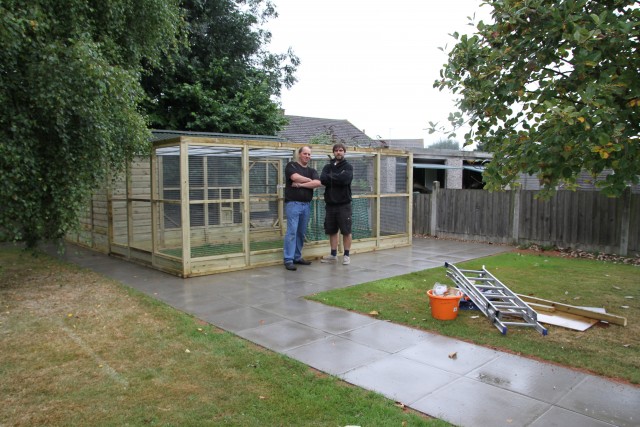 Simon and craig proudly stanf in front of th echicken house they have just finished.